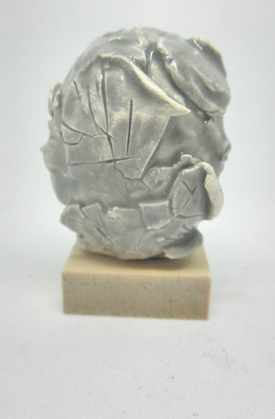 Miniature ceramic collector sculpture of a face surrounded by leaves - grey