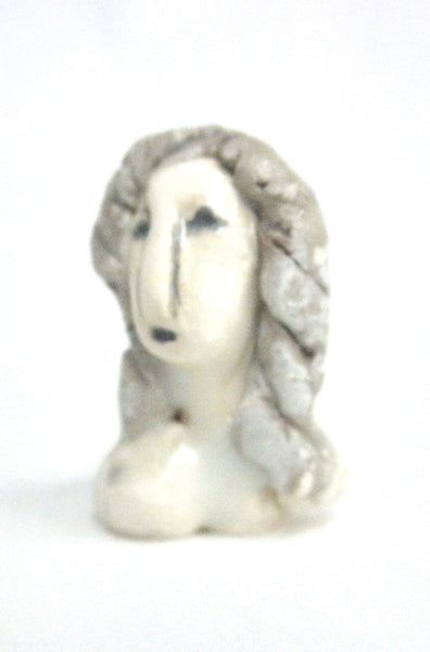 Miniature ceramic sculpture of a woman in grey tones