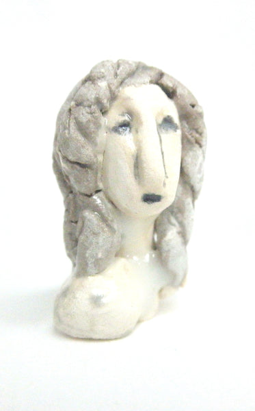 Miniature ceramic sculpture of a woman in grey tones