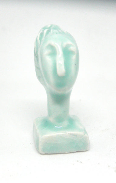 Miniature ceramic collector sculpture of a woman with sweeping hair