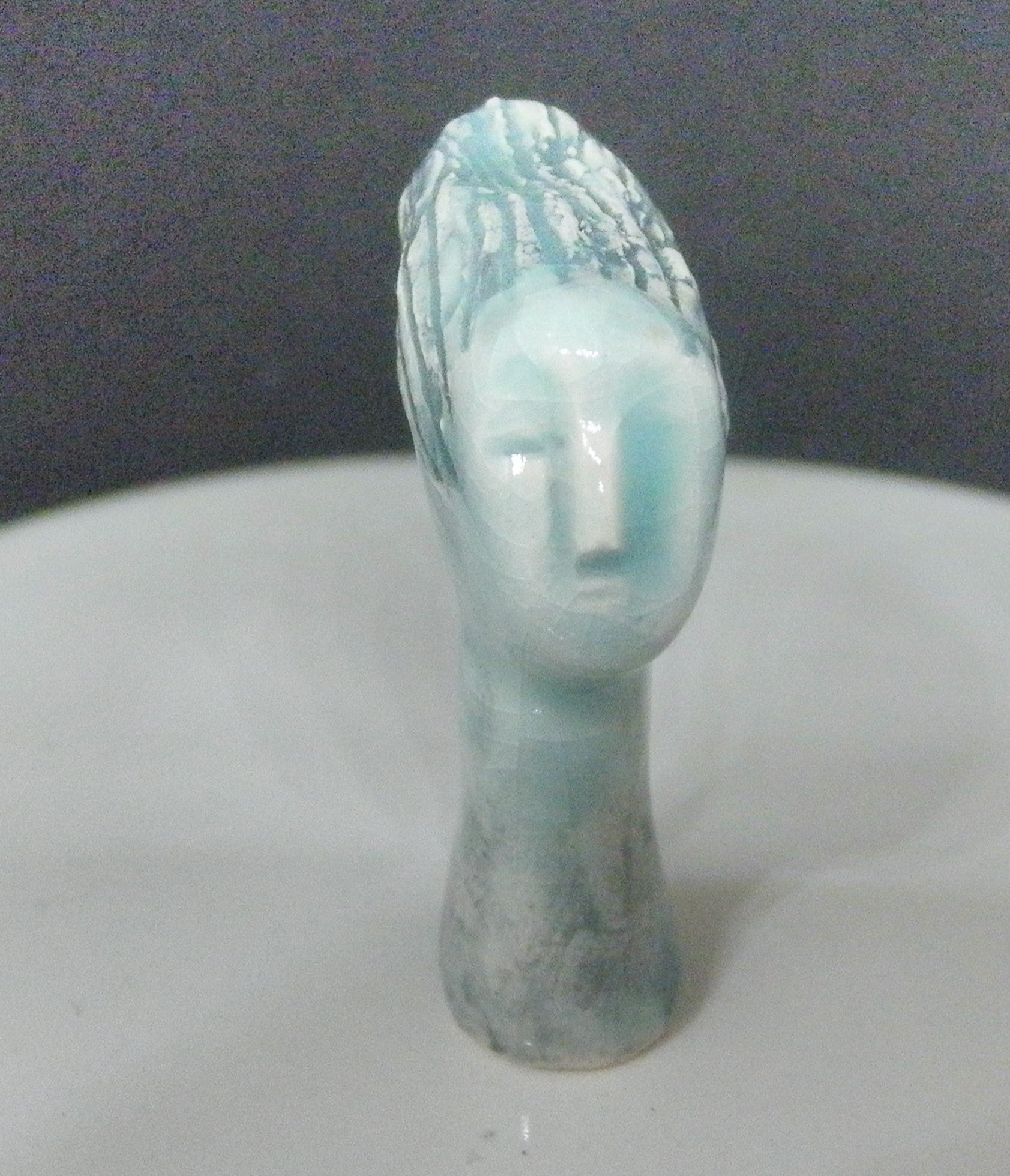 Miniature ceramic collector sculpture of a woman with sweeping